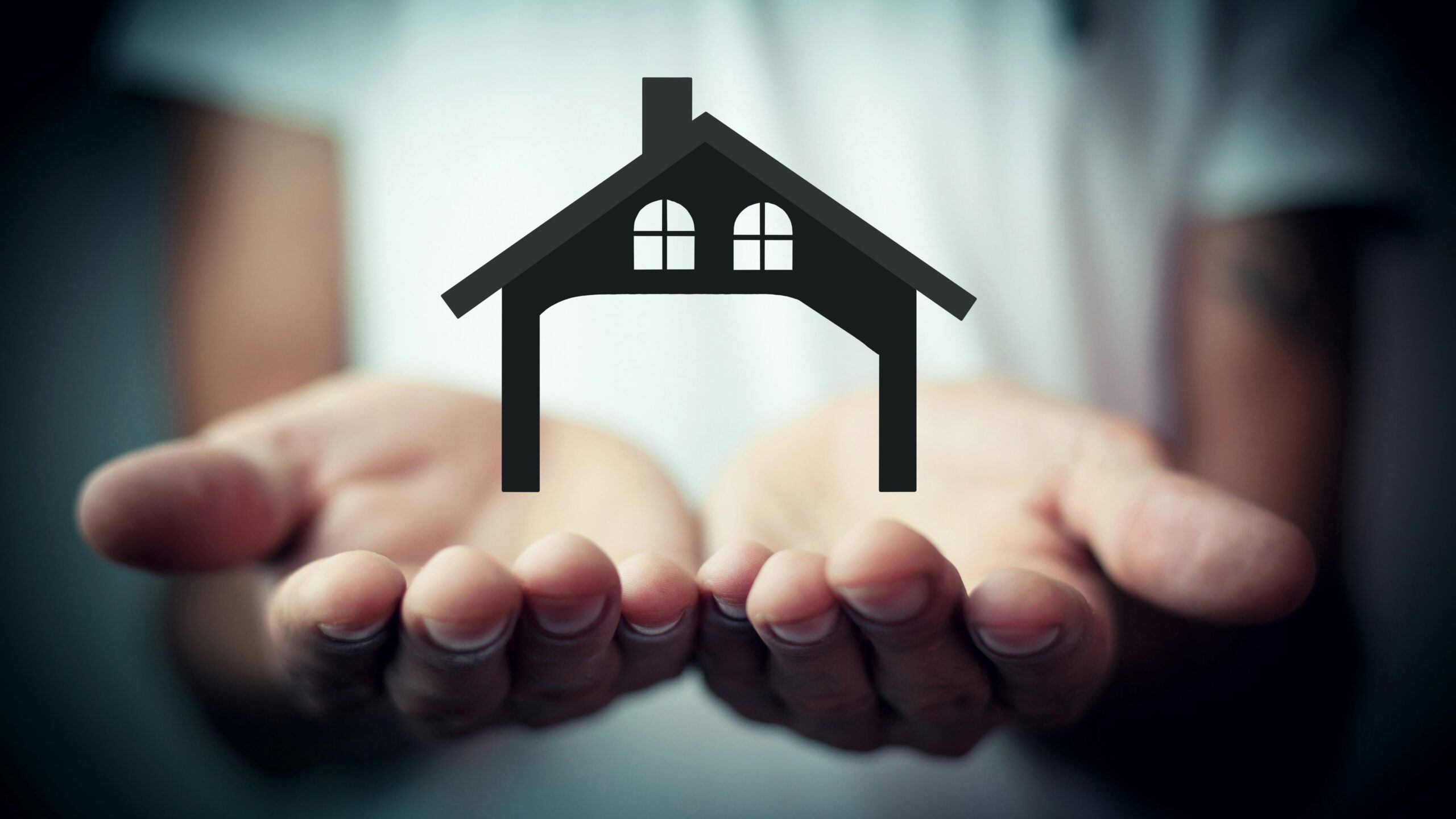 Hands holding a silhouette of a house