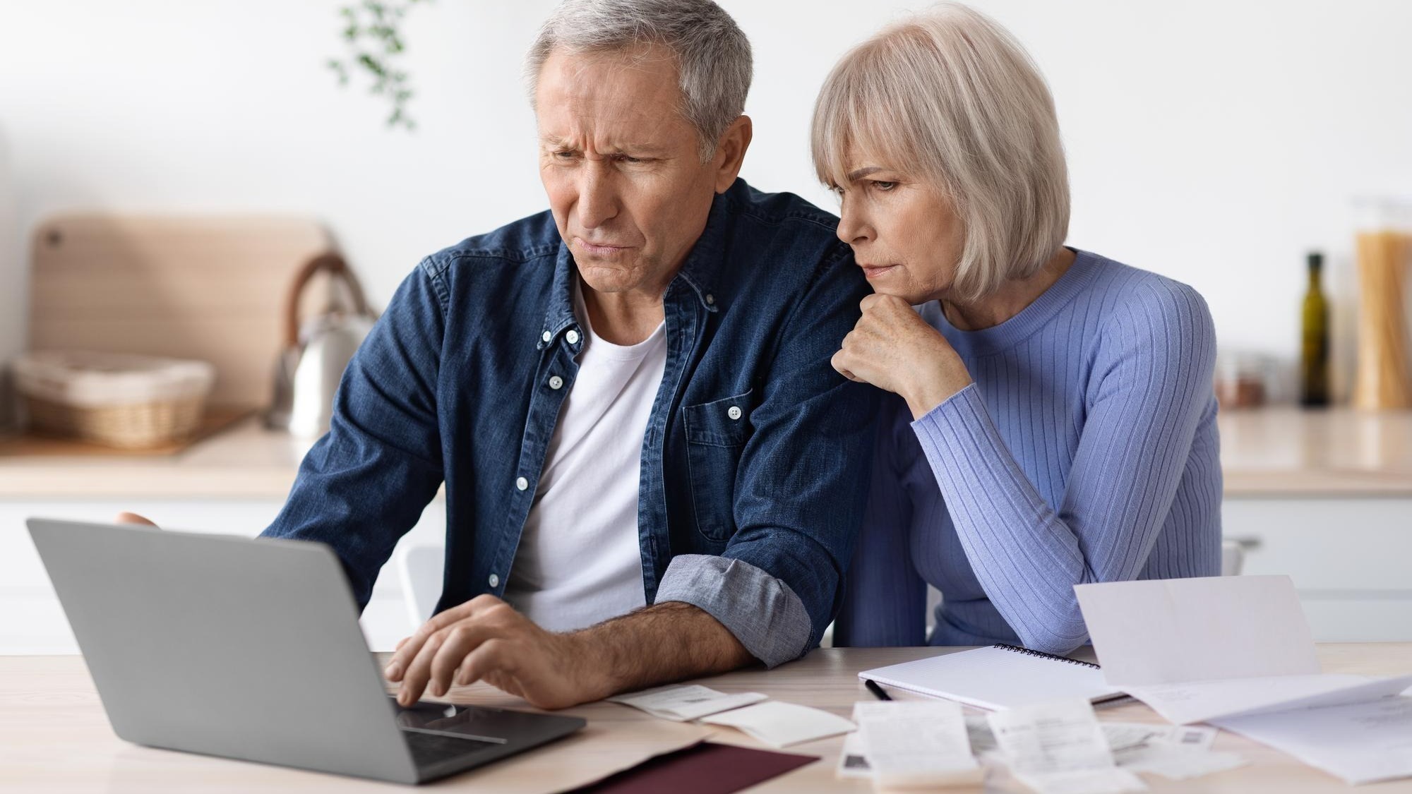 Confused senior husband and wife paying bills on Internet