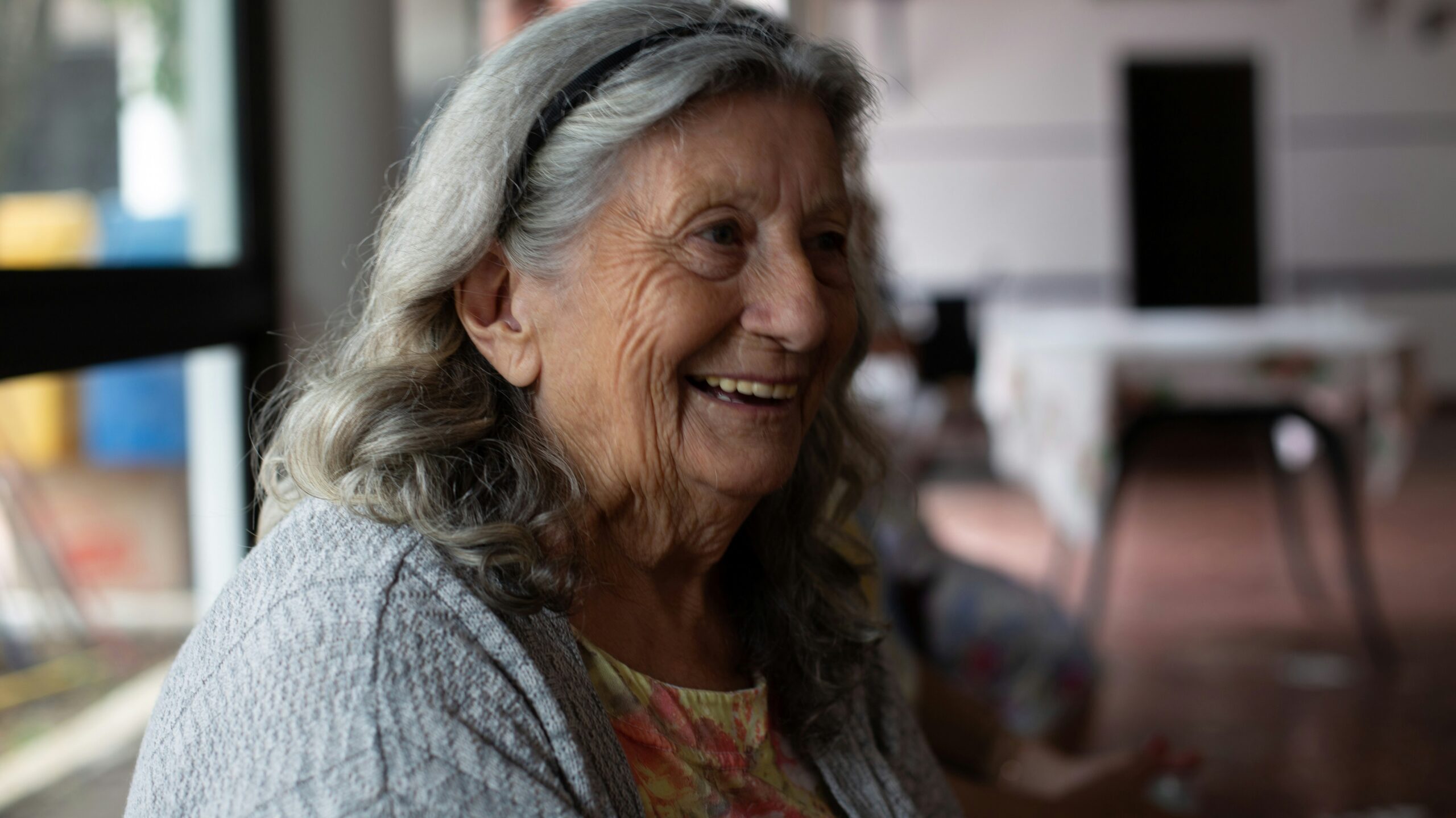 smiling woman in gray cardigan