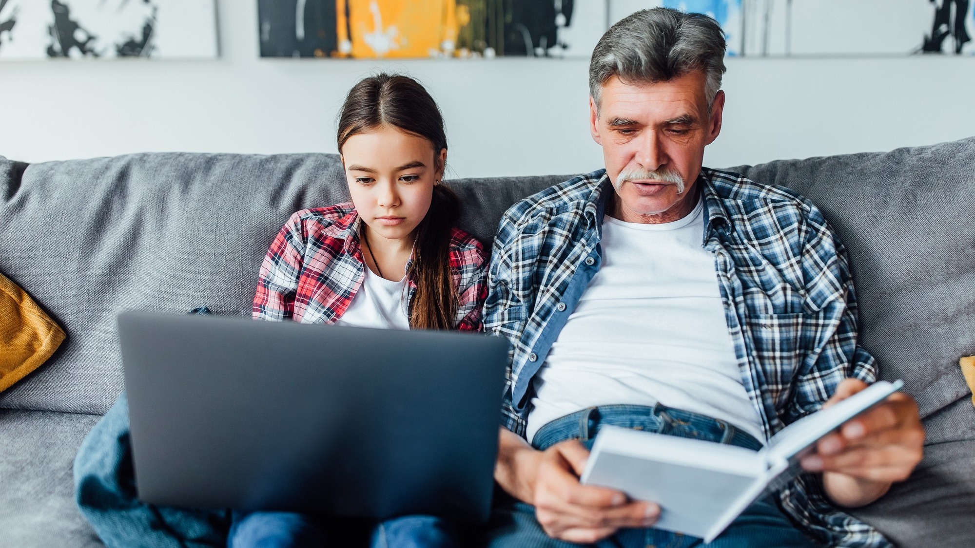 Family time! Grandfather helping granddaughter with homework.