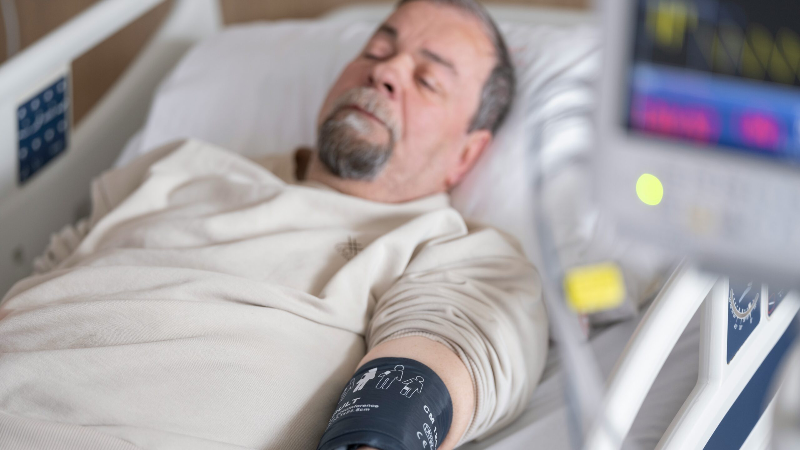 a man laying in a hospital bed with an iv
