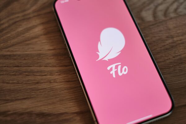 A pink phone sitting on top of a wooden table