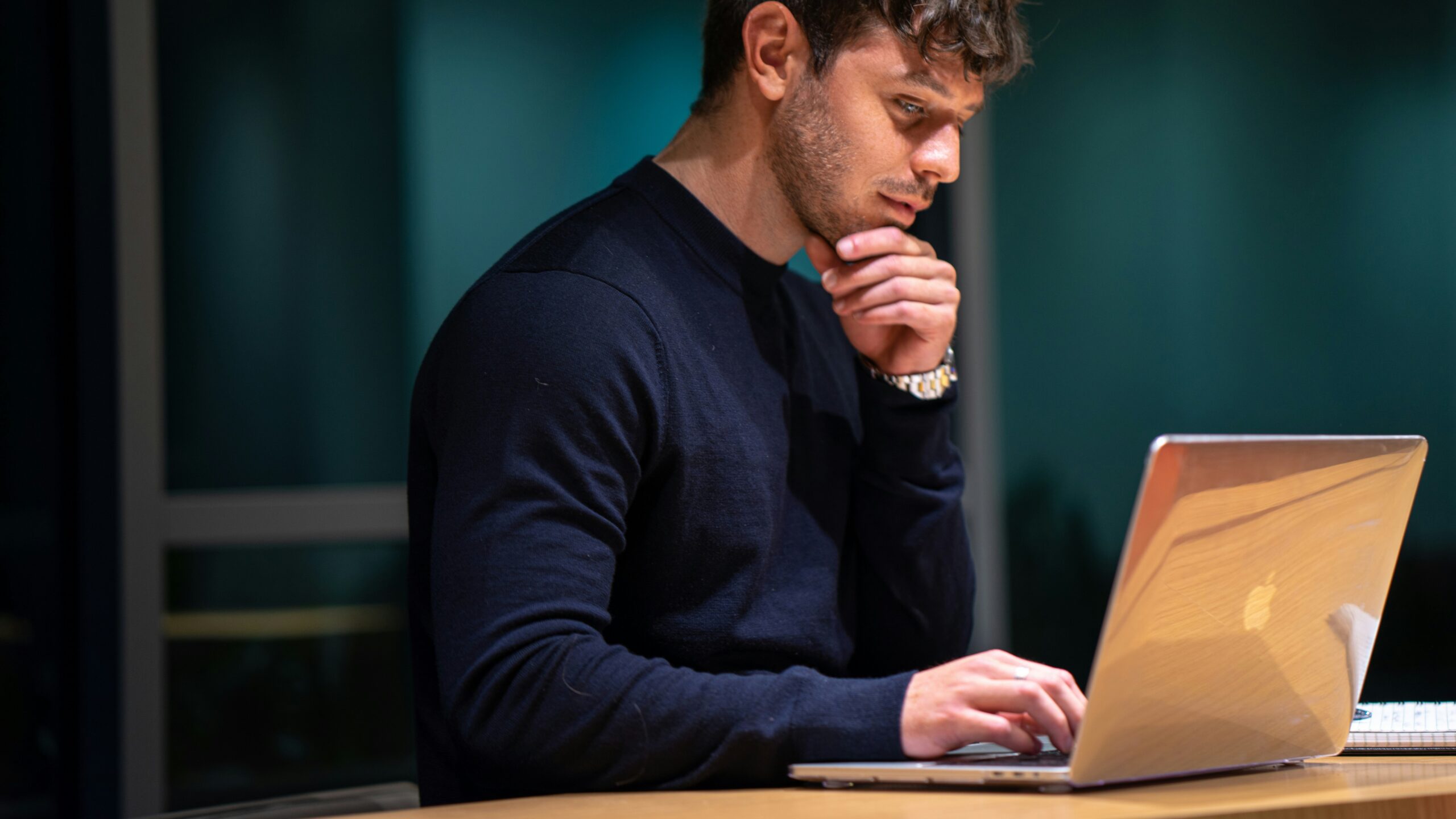 man in black long sleeve shirt sitting in front of macbook