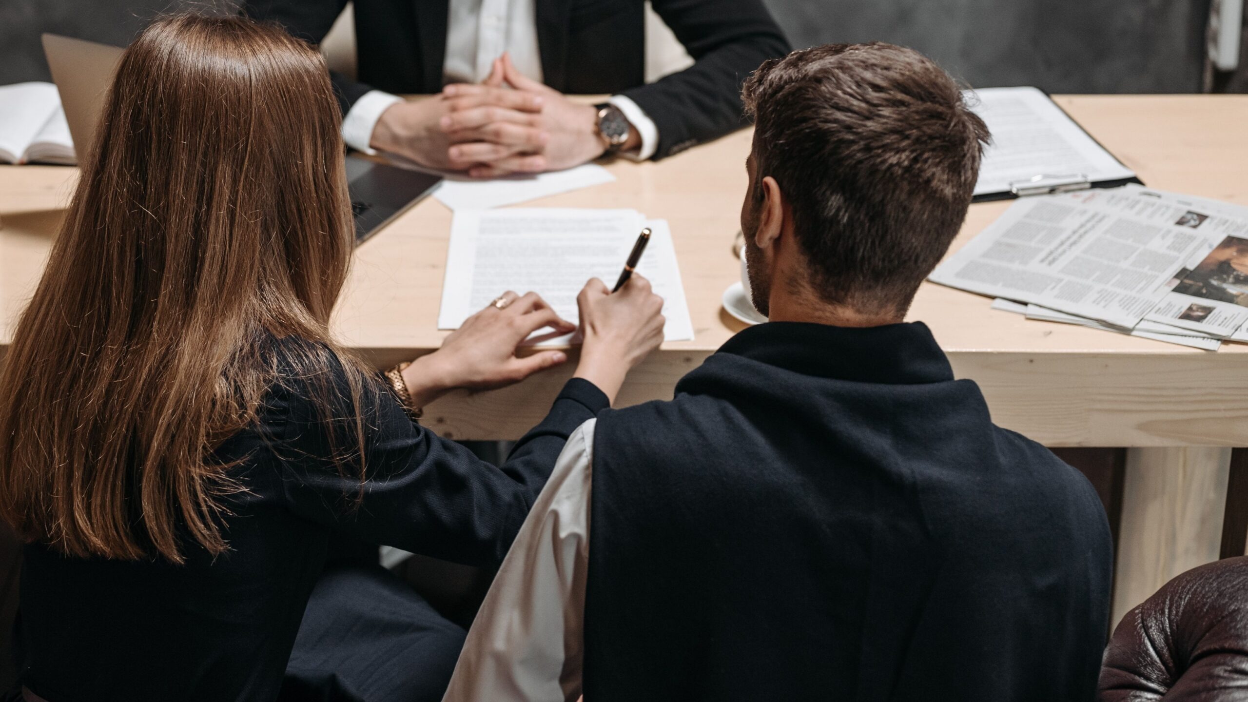 A lawyer discusses legal documents with clients in an office setting.