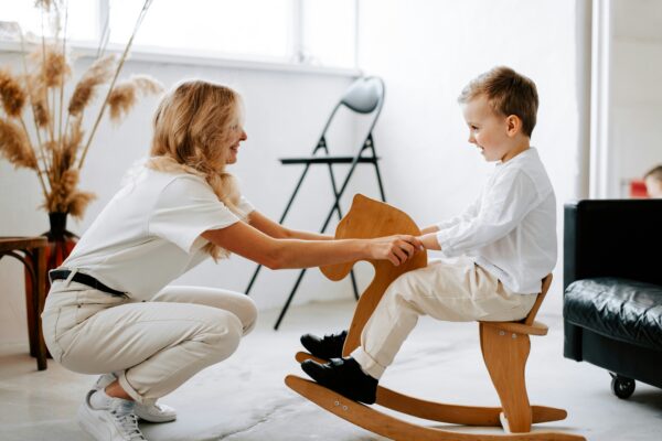 a woman and a child playing on a rocking chair