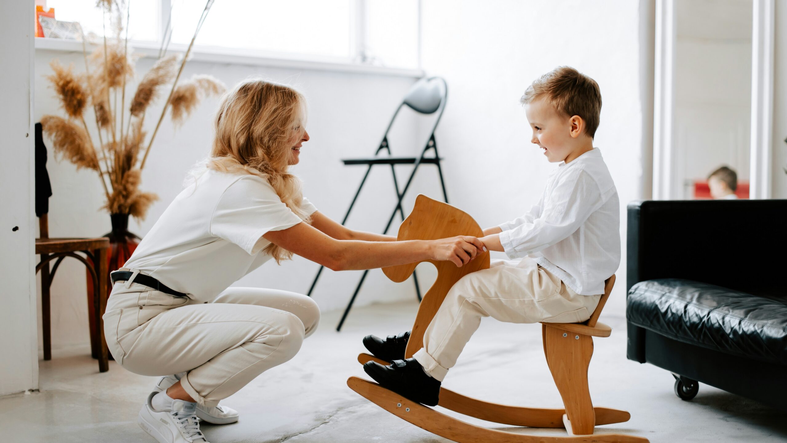 a woman and a child playing on a rocking chair