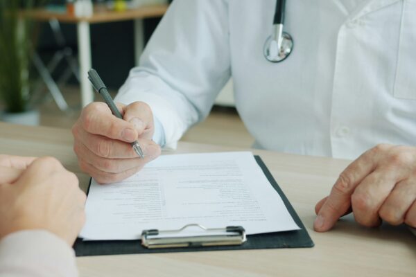 Doctor writing on a patient's chart