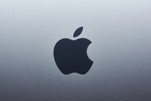 A dark apple logo centered on a smooth grey metallic surface