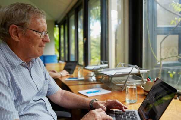 a man sitting at a table using a laptop computer