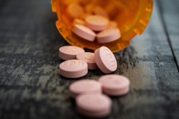 white medication pill on orange plastic container
