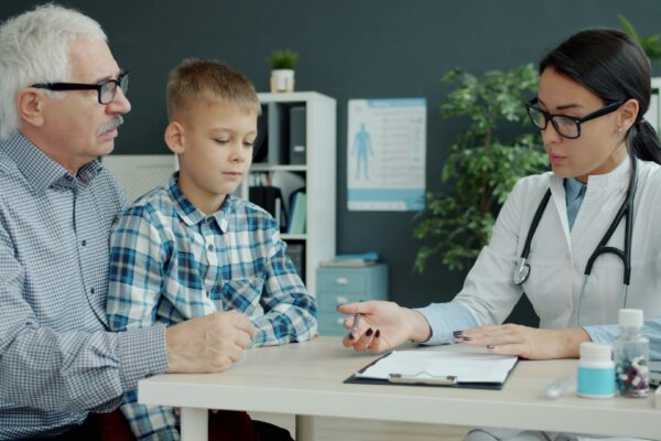 Doctor consults with grandfather and grandson in office