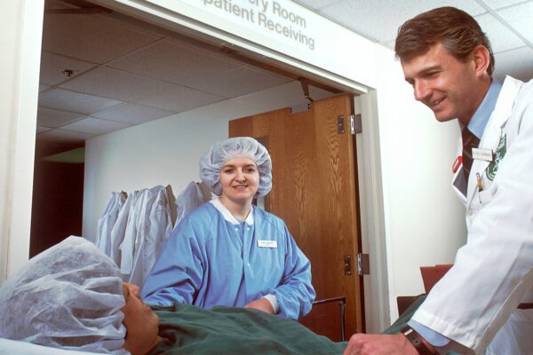 woman in blue scrub suit standing beside woman in white robe