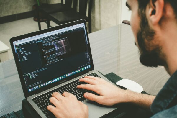 man programming using laptop