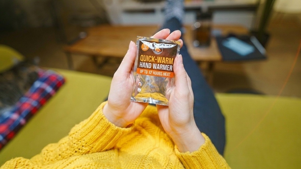 A woman holding a cup of coffee in front of a TV