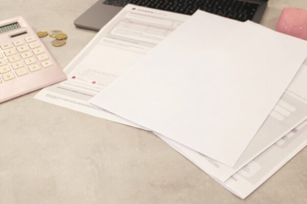 Bills and calculator sit on a desk