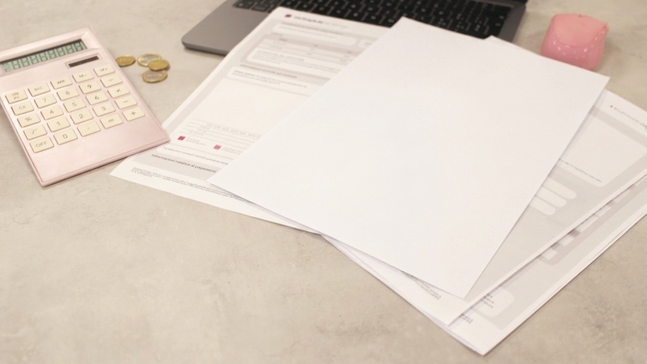 Bills and calculator sit on a desk
