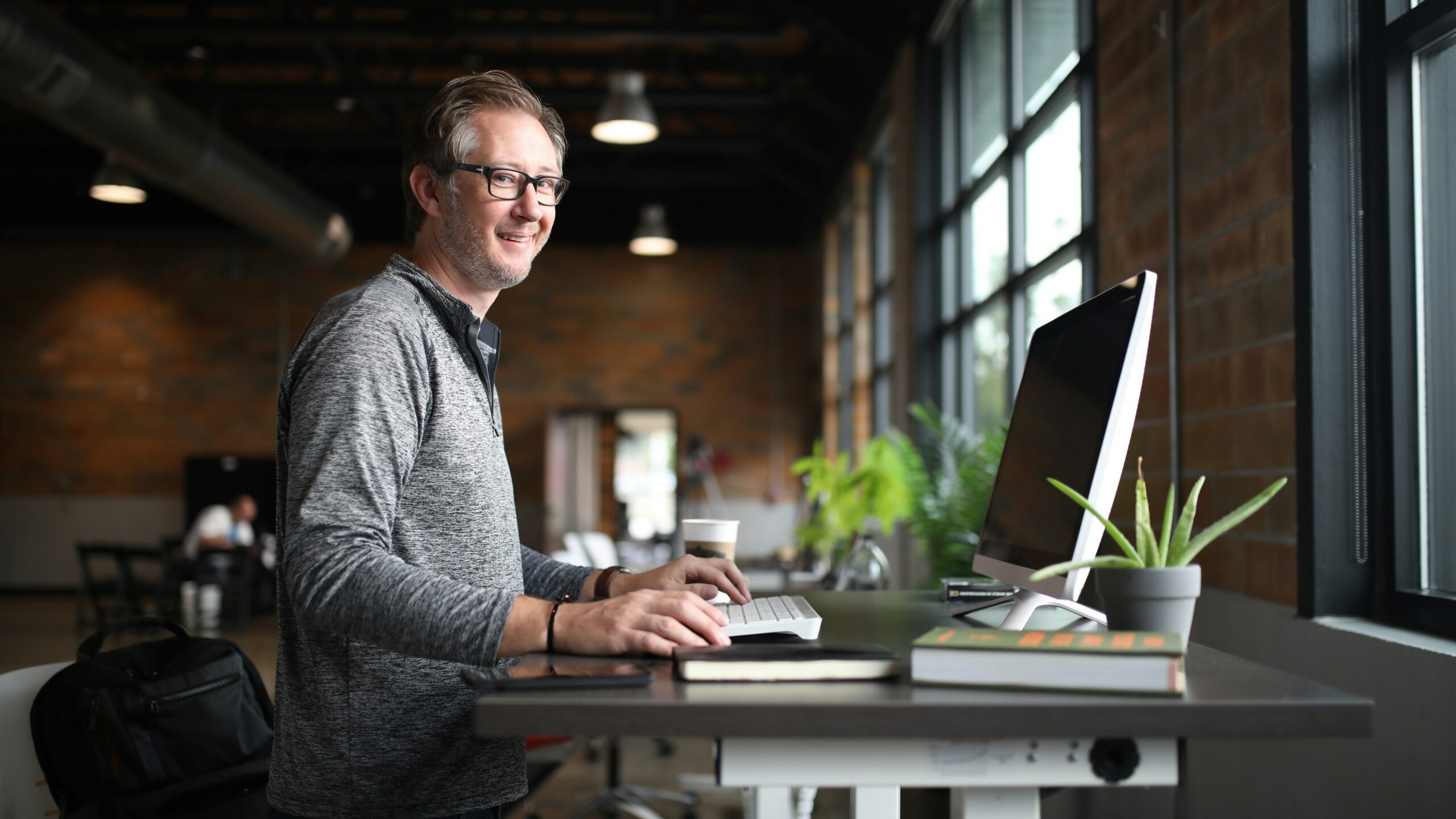 a man sitting at a desk with a laptop