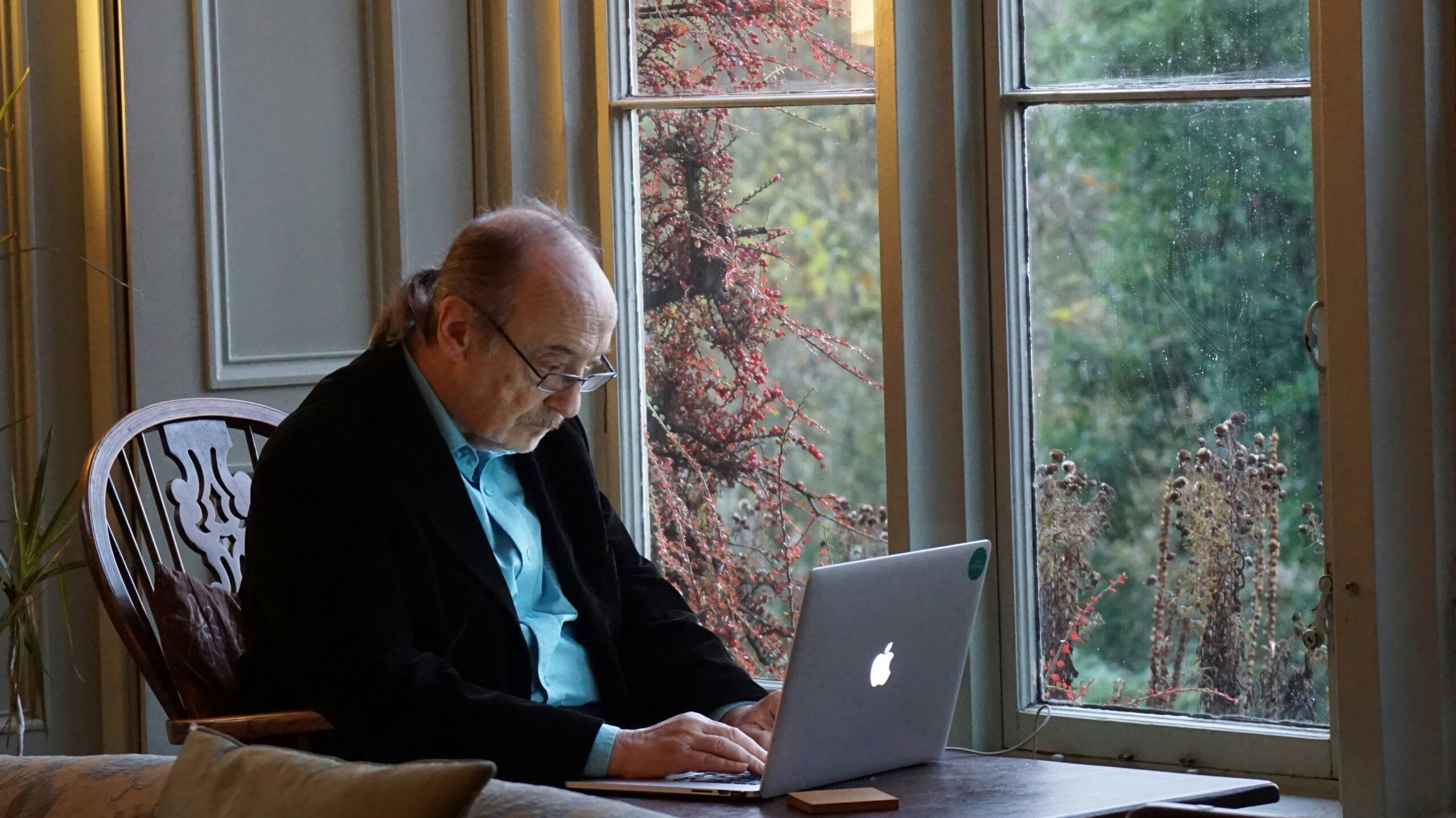 man in black suit jacket using macbook