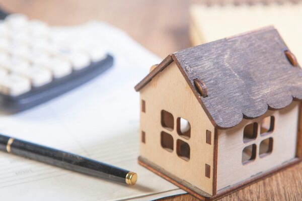 Model house with calculator and pen on desk