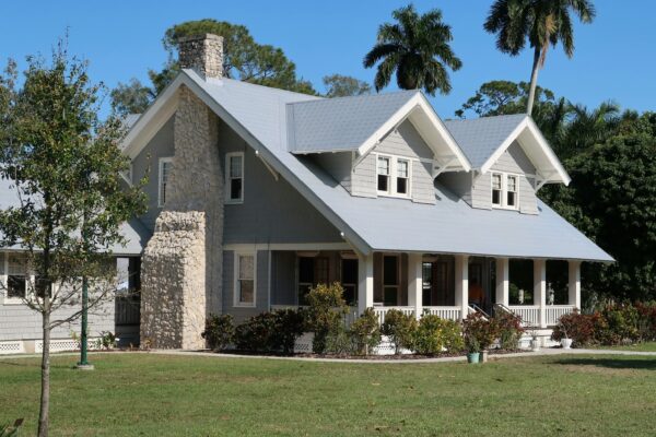 A grey house with a stone chimney and porch in Fort Myers, Florida