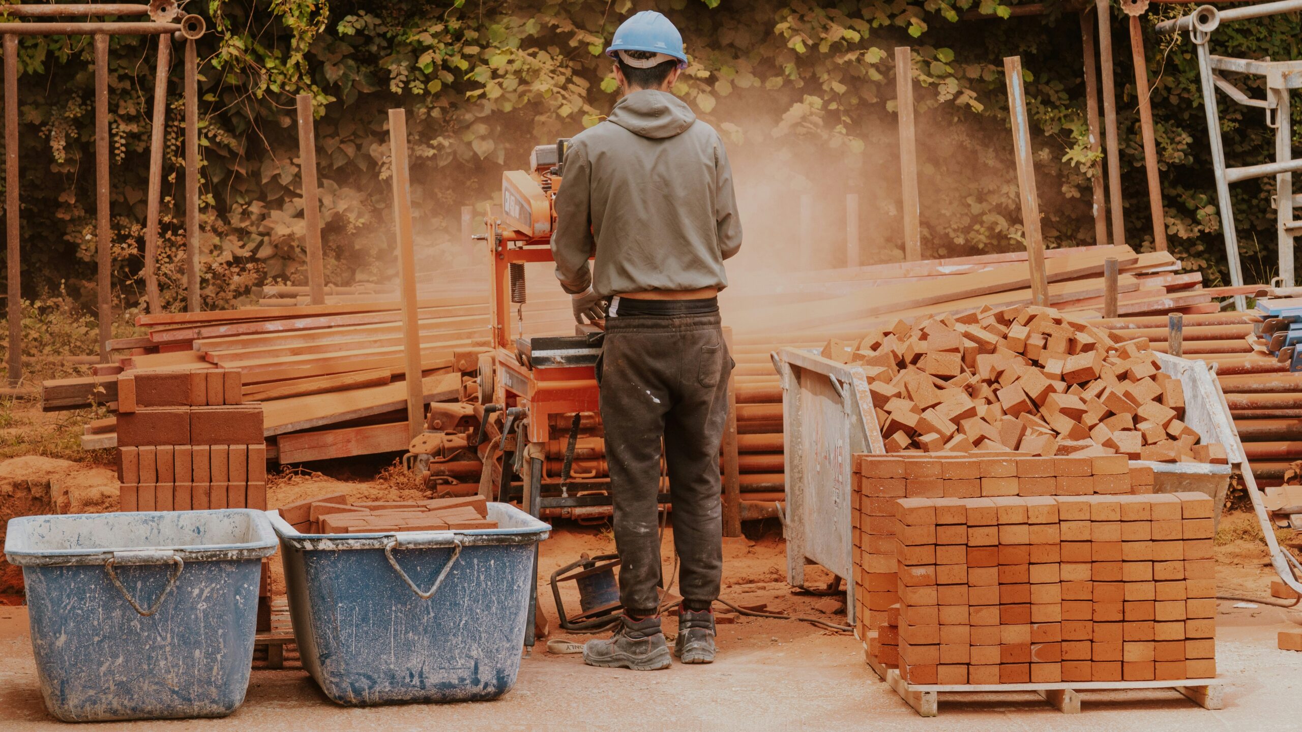 a man standing in front of a pile of wood