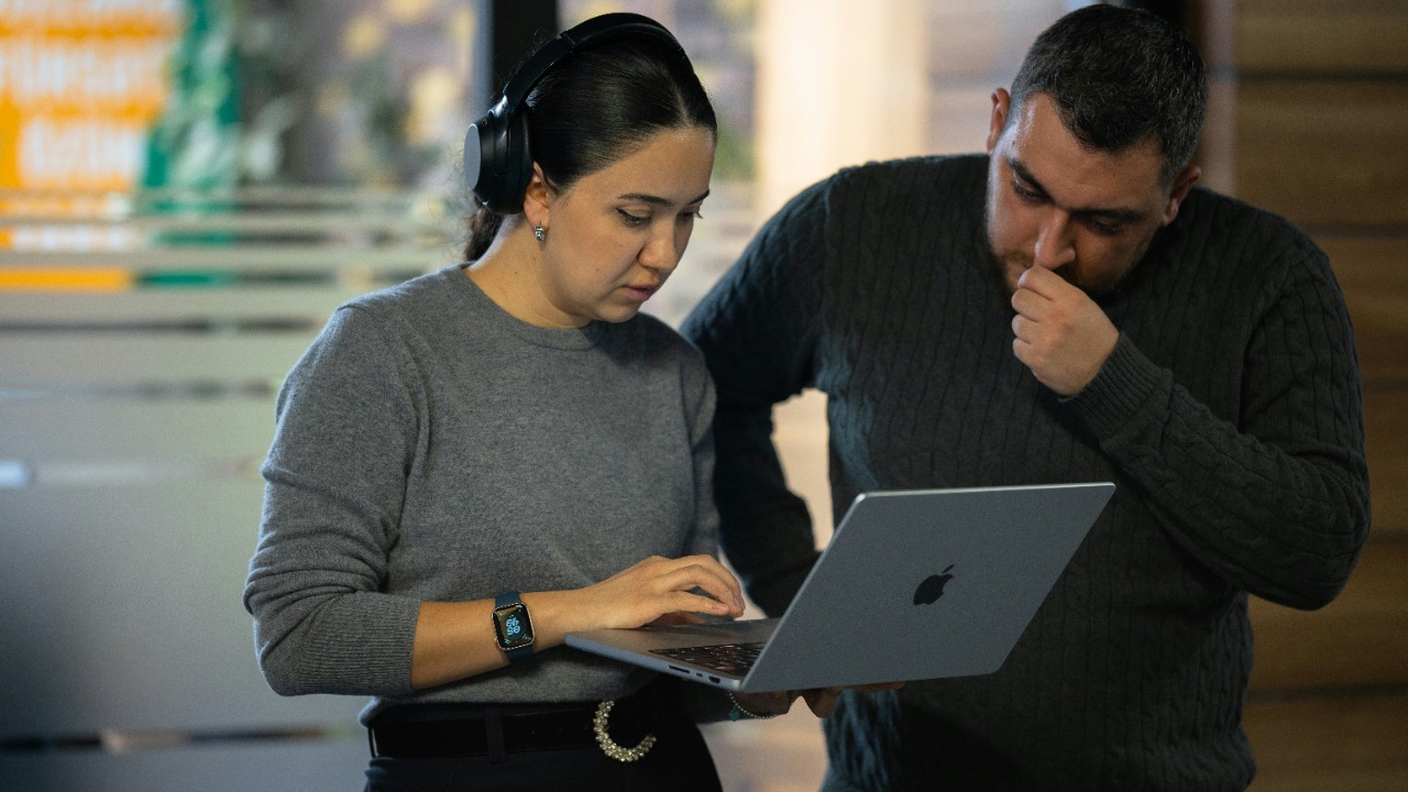A man and a woman looking at a laptop