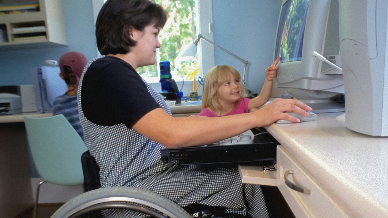 a woman in a wheel chair working on a computer