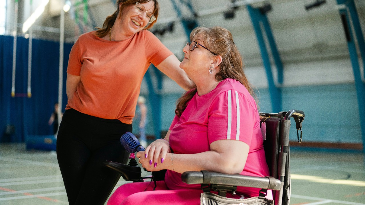 Two women talking in a gymnasium