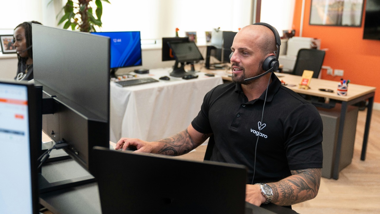 a man wearing a headset sitting in front of a computer