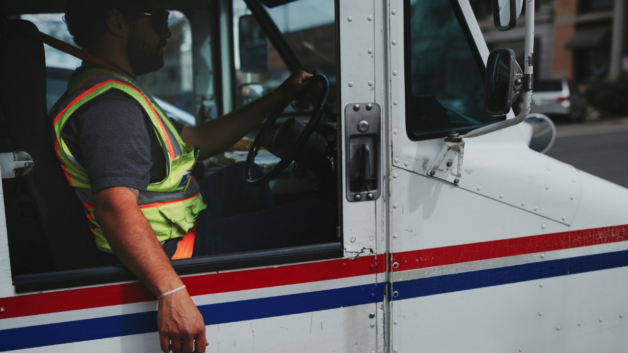 Mail carrier driving a white truck