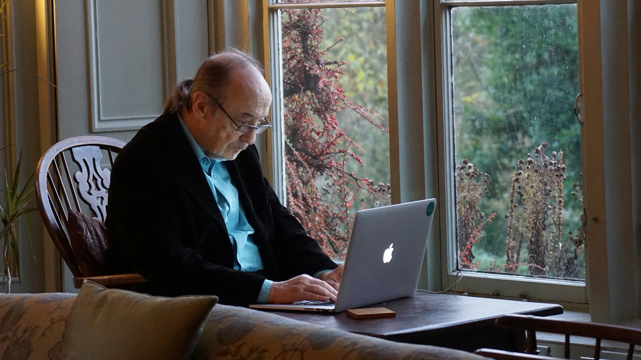 man in black suit jacket using macbook