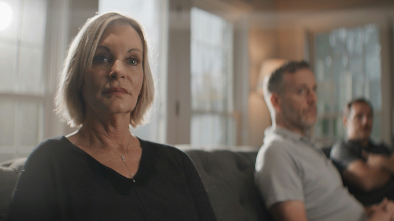 An older woman and two men sitting on a couch