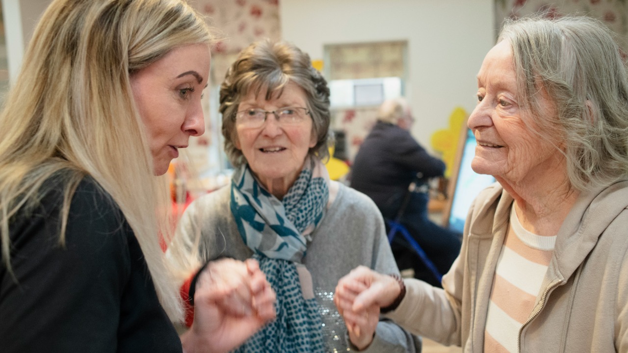 Three women interacting indoors with soft lighting