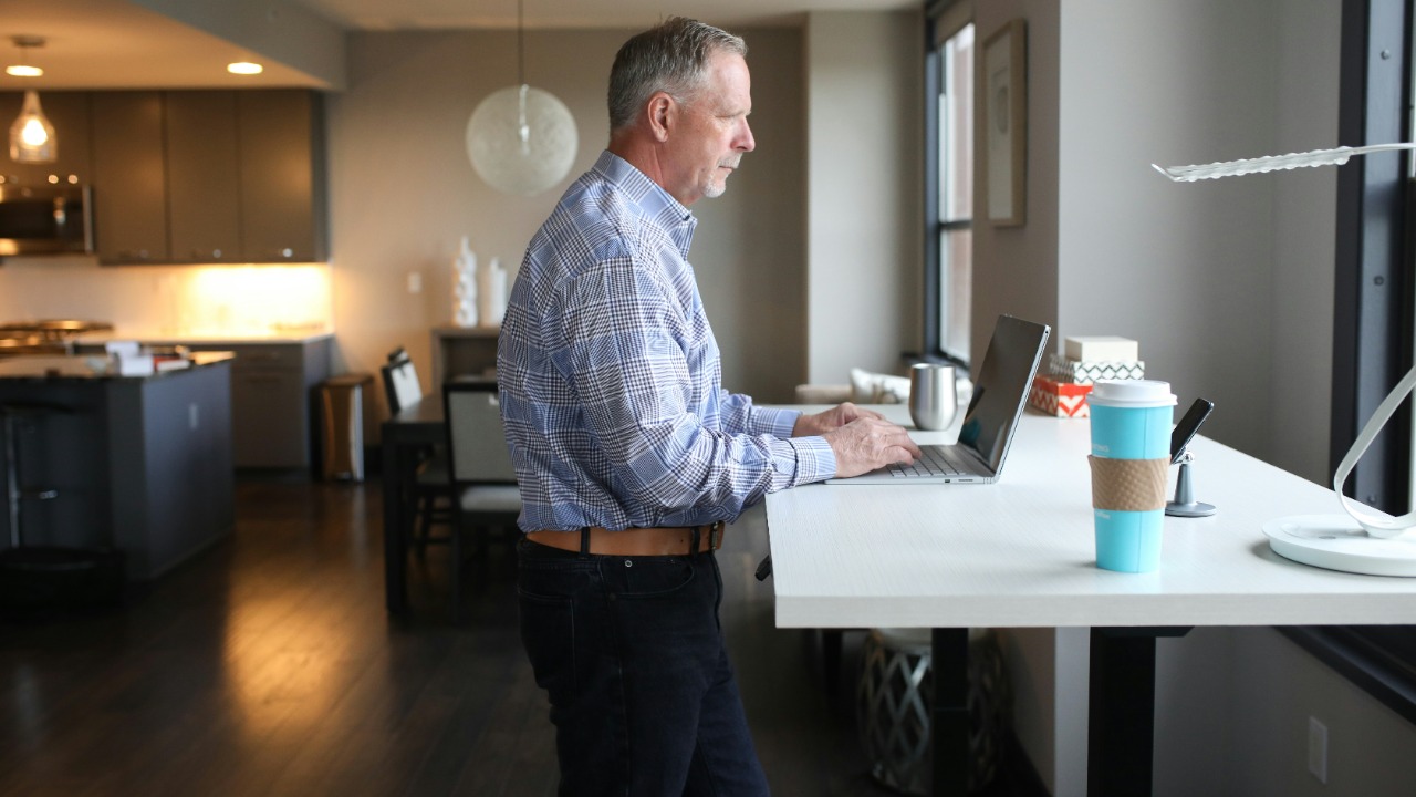 man in blue and white plaid dress shirt standing near white table