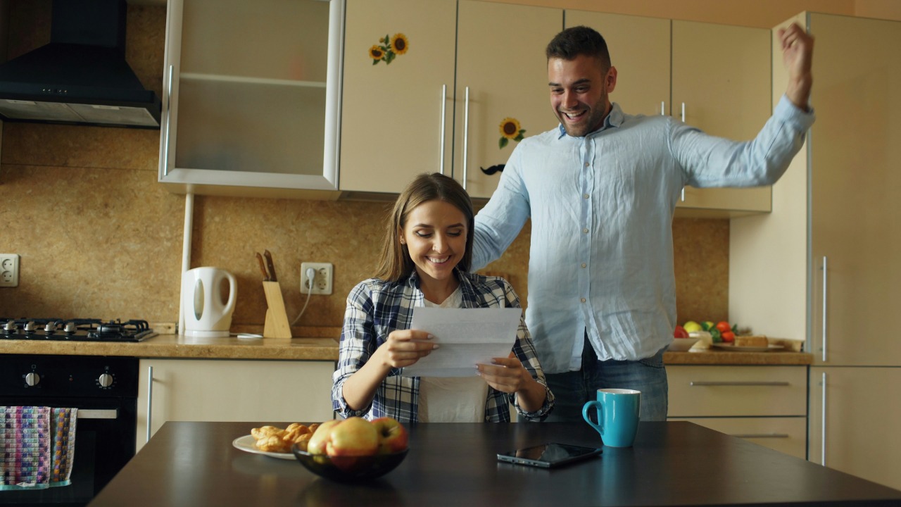 Couple celebrating good news in the kitchen