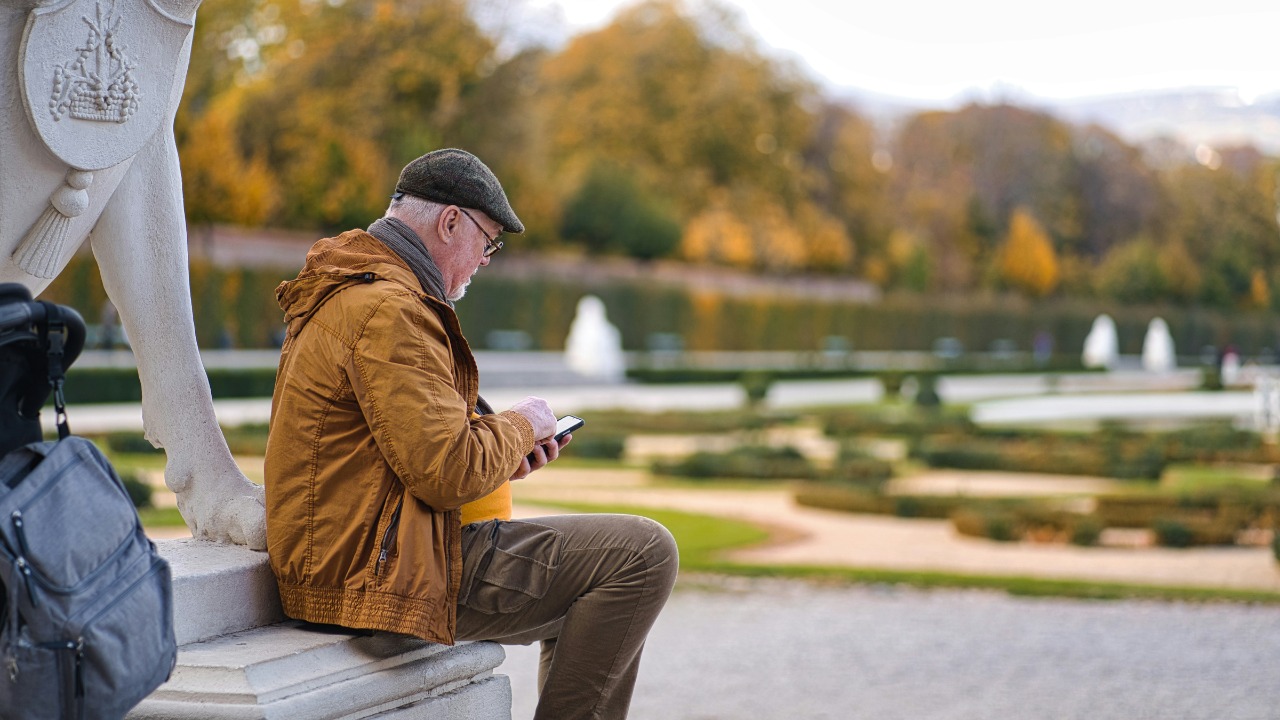 a man sitting on a bench looking at his phone