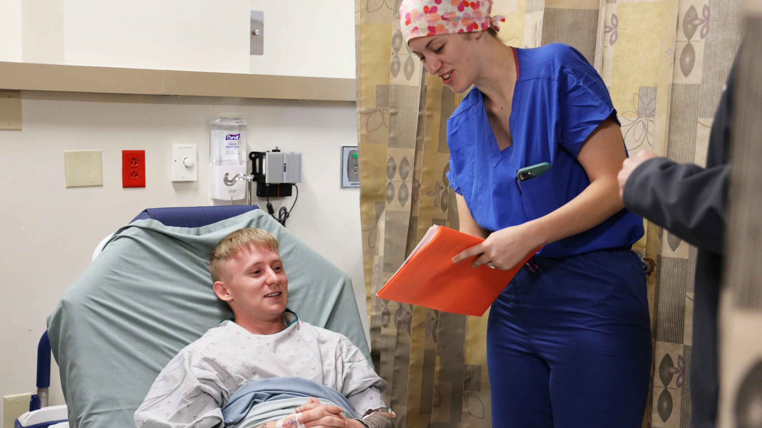 Nurse talking to patient in hospital bed