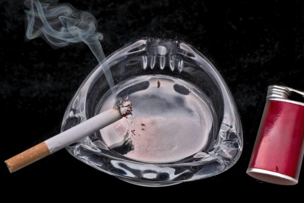 cigarette stick on blue and white ceramic round ashtray