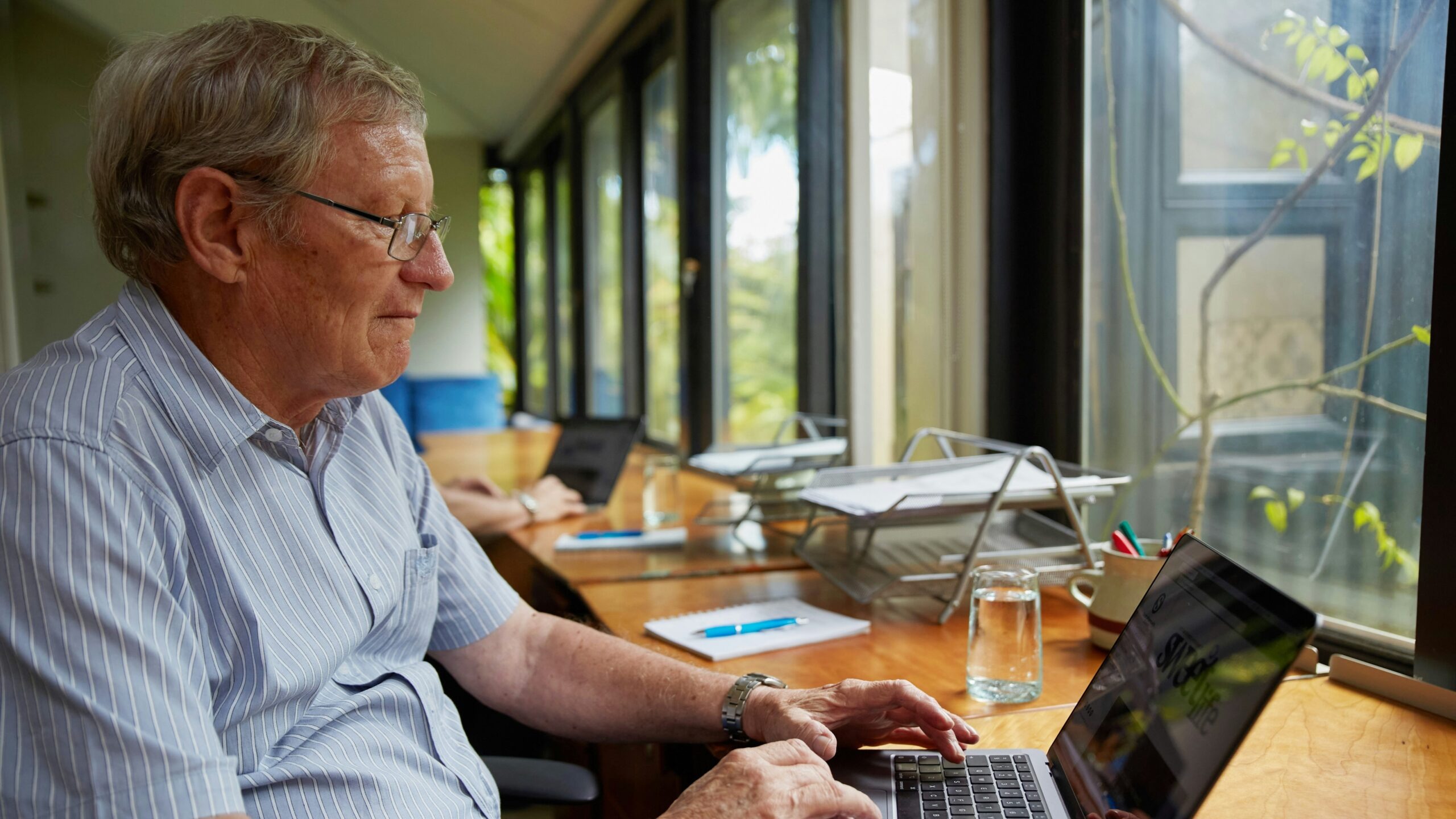 a man sitting at a table using a laptop computer