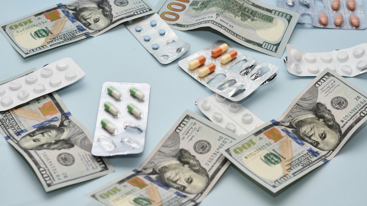 a pile of pills and money sitting on top of a table