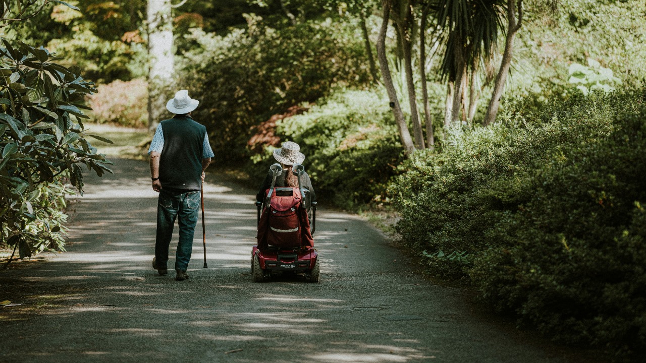 a man and a woman walking down a dirt road