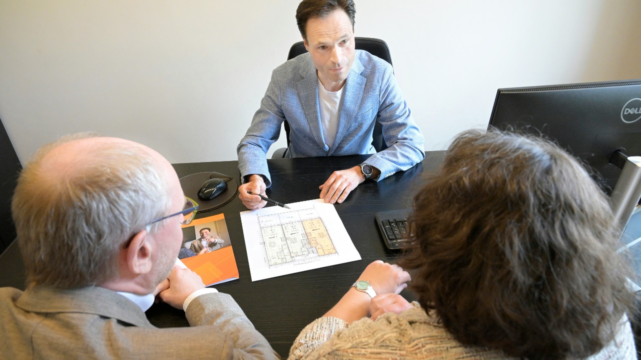 Consultant explains plans to a couple during a business meeting