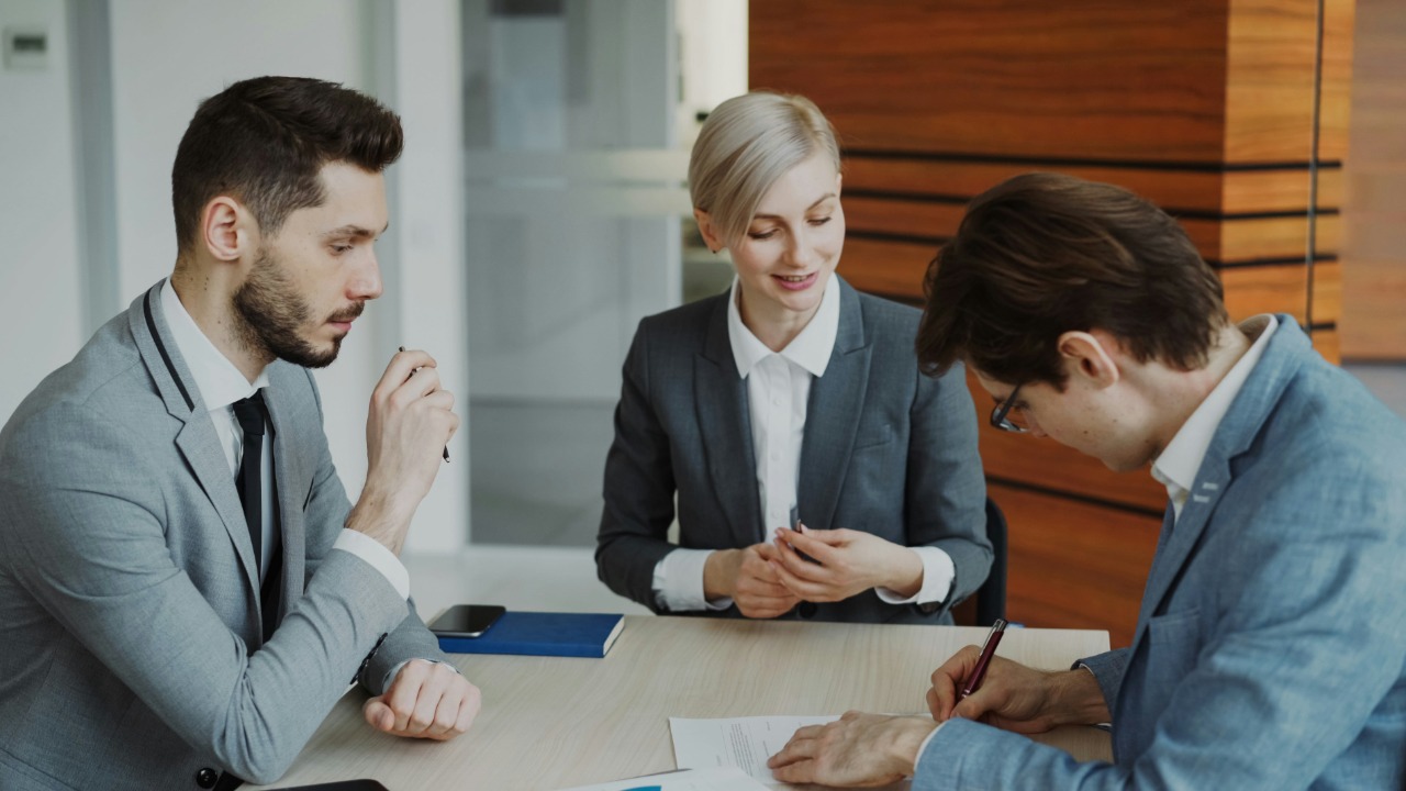Business people signing a contract at a table