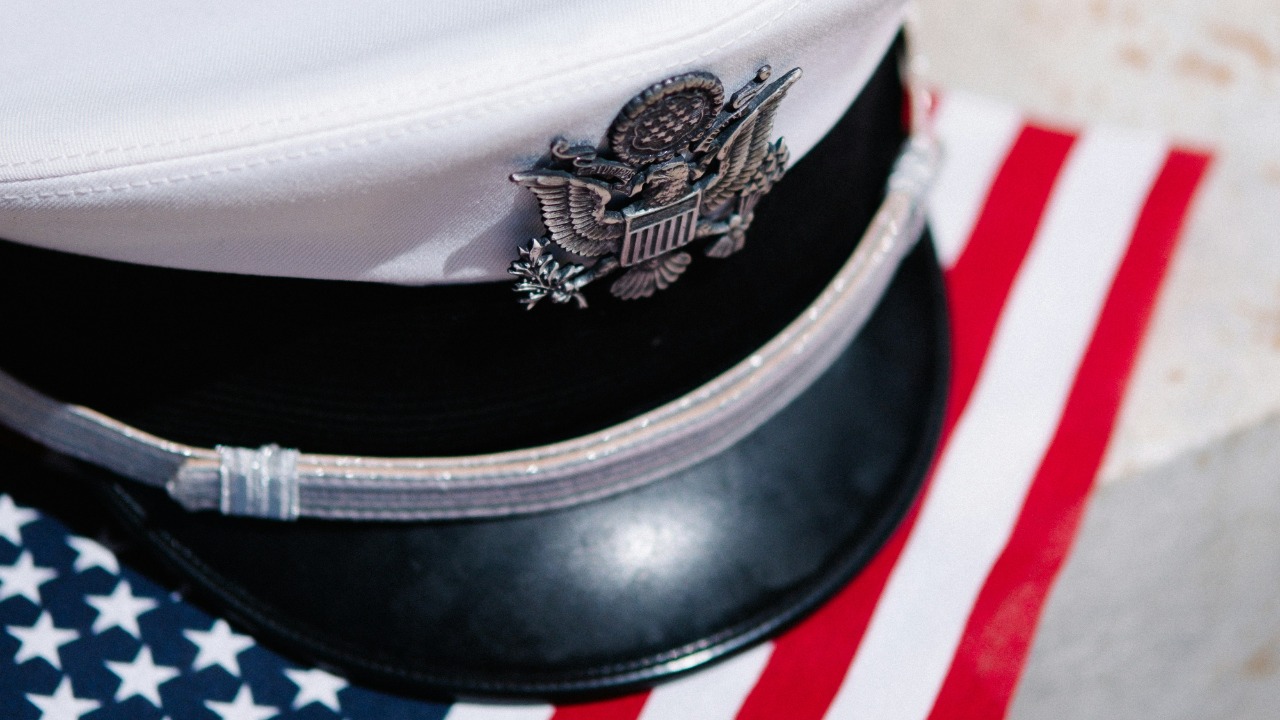 a white hat sitting on top of an american flag