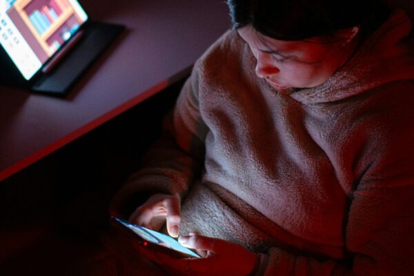A person sitting in a chair looking at a cell phone