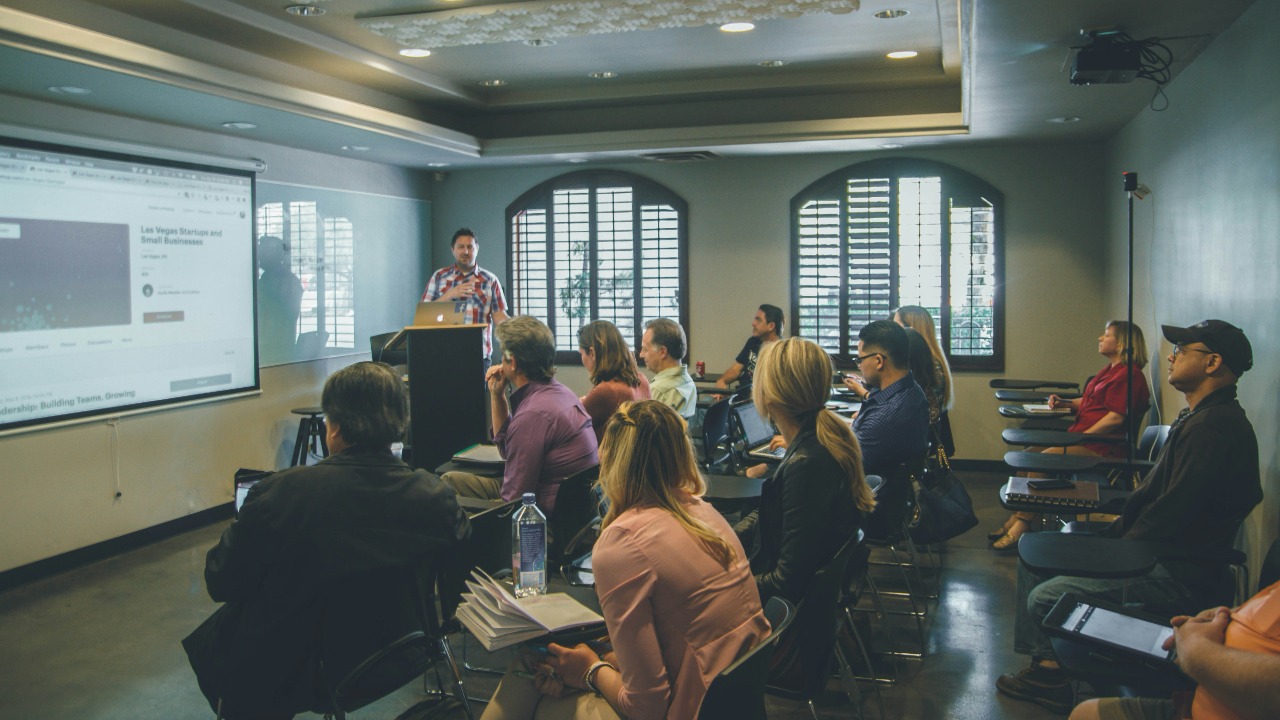 a group of people in a room with a projector screen
