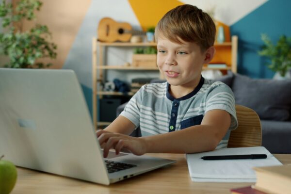 Young boy learning on a laptop at a desk