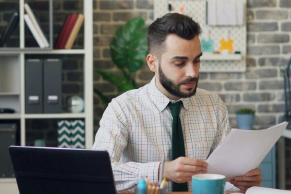 a man sitting at a desk in front of a laptop